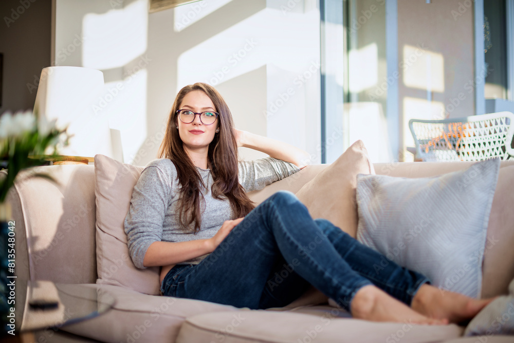 Full length a confident young woman relaxing on the sofa at home Full length a confident young woman relaxing on the sofa at home