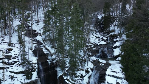 View of a waterfall during winter. Cold and frost in the forest. Winter adventure and hiking. Kozice Waterfall near Fojnica in Bosnia and Herzegovina. photo