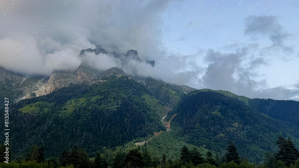 Cloudy alpine landscape with lush greenery and mountain peaks, ideal for nature and hiking themes, related to Earth Day and environmental awareness