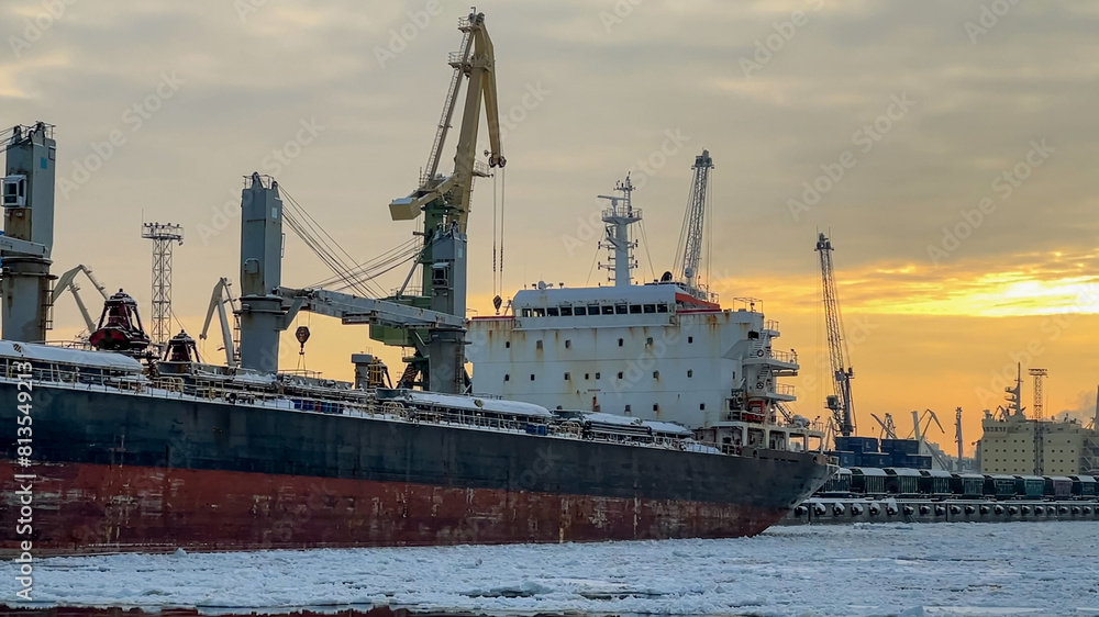 Sea port in winter with ice at the sunset time