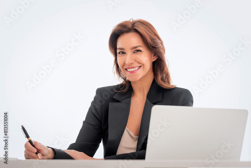Businesswoman sitting at desk and using laptop against isolated background