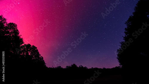Star filled night sky illuminated by the bright magentas of the Aurora Borealis over the Dordogne region of France