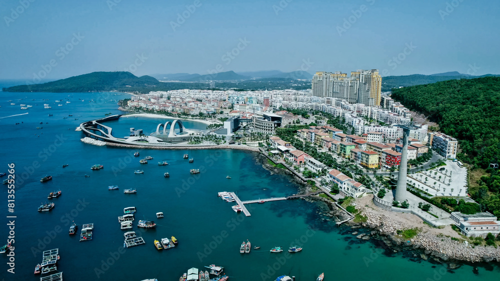 Fototapeta premium Aerial view of a bustling coastal city with modern architecture and a marina, ideal for travel, urban development, and holiday themes
