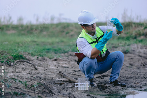 Asian man environment researcher holds tube of sample water to inspect from the lake. Concept, explore, analysis water quality from natural source. Ecology field research