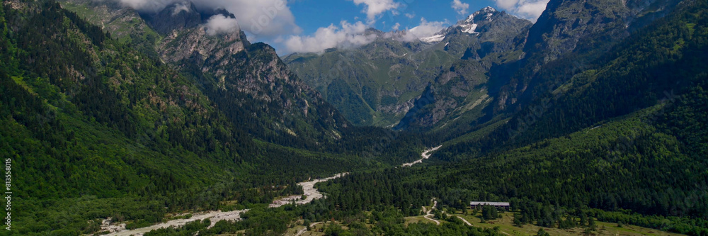 Breathtaking panoramic view of vibrant green meadows leading to snow-capped peaks under a blue sky, ideal for nature and travel themes, Earth Day promotions Breathtaking panoramic view of vibrant green meadows leading to snow-capped peaks under a blue sky, ideal for nature and travel themes, Earth Day promotions