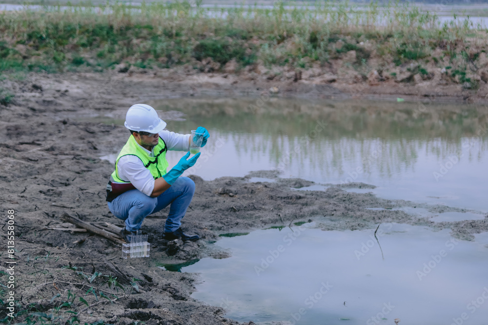 Asian man environment researcher holds tube of sample water to inspect from the lake. Concept, explore, analysis water quality from natural source. Ecology field research Asian man environment researcher holds tube of sample water to inspect from the lake. Concept, explore, analysis water quality from natural source. Ecology field research