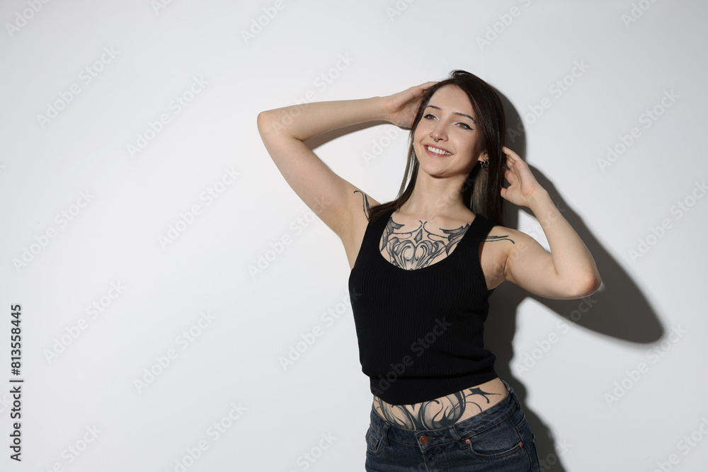 Portrait of smiling tattooed woman on light background. Space for text Portrait of smiling tattooed woman on light background. Space for text