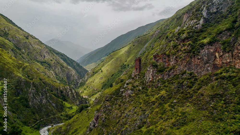 Panoramic view of misty green mountains with an ancient solitary tower, ideal for articles on hiking, nature conservation, and Earth Day backgrounds