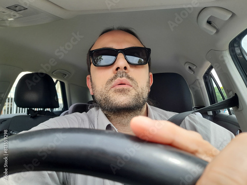 Uomo alla guida della propria automobile per le strade della città photo