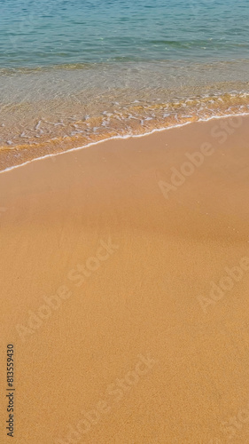Tranquil sandy beach with gentle waves, ideal for travel and summer vacation concepts, potentially related to World Oceans Day