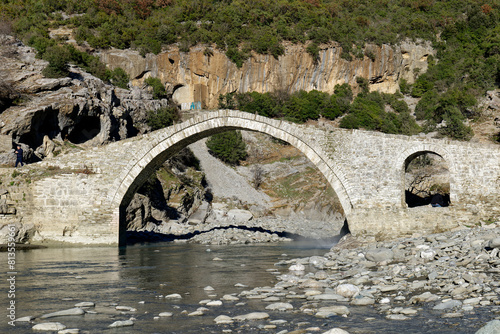 View of the Kadiut Bridge in Benje, Permet, Albania. Ancient stone bridge. Beautiful natural wonders. Holidays and leisure time. Fisherman fishing in the river. Natural thermal baths. photo