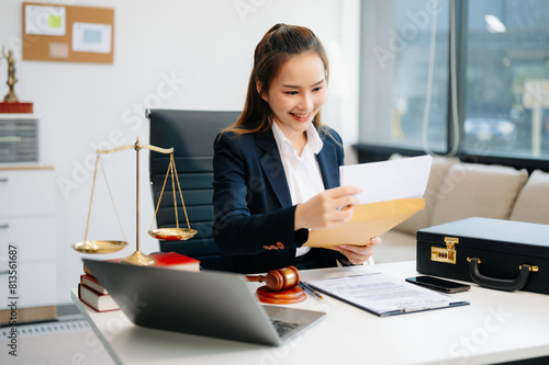 Asian lawyer woman working with a laptop and tablet in a law office. Legal and legal service concept.