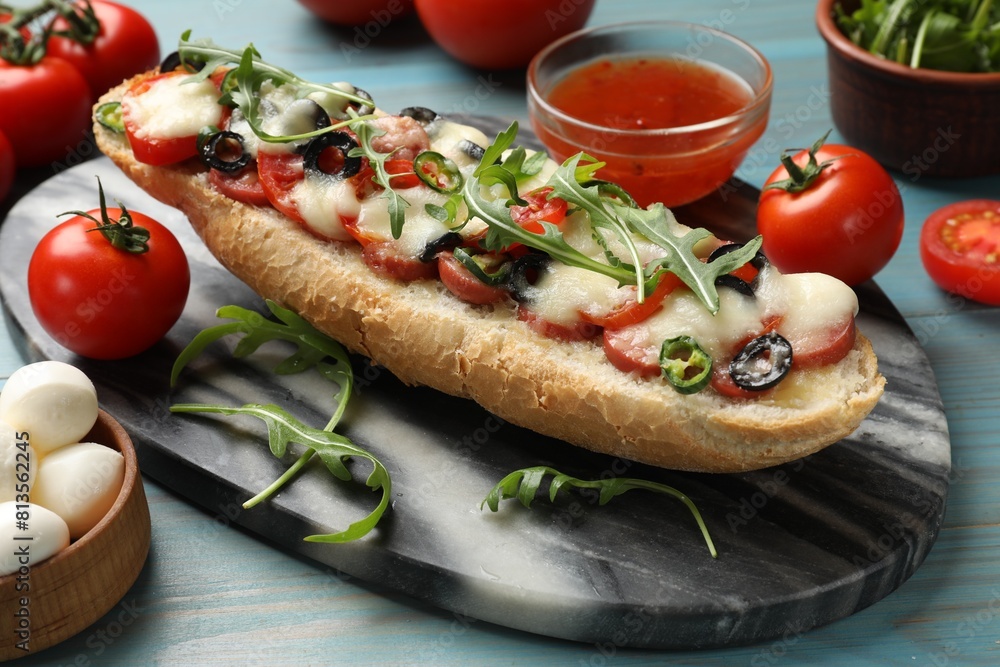 Tasty pizza toast and ingredients on light blue wooden table