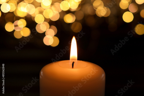 Burning candle in darkness  closeup. Bokeh effect