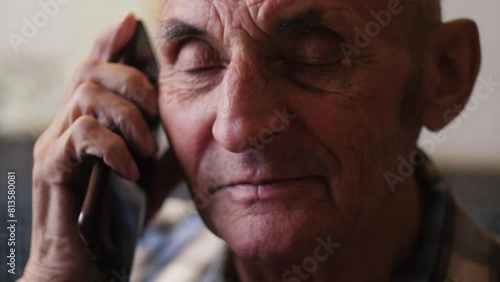 portrait of a cheerful Caucasian pensioner 70 -79 years old talking on the phone. emotions of older people photo