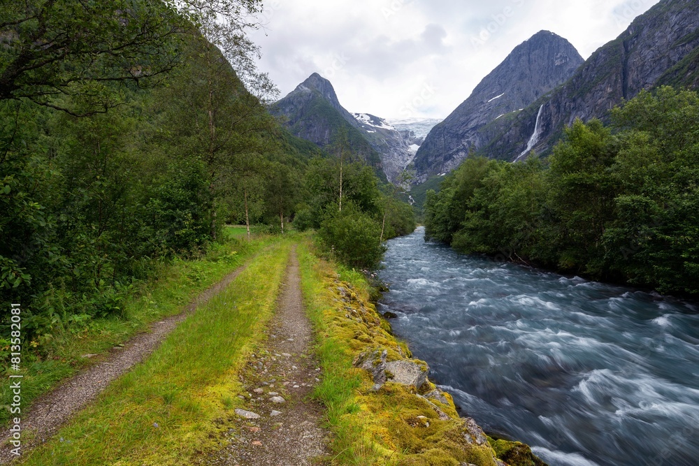 Beautiful view of a river by the road in a forest with trees and mountain Beautiful view of a river by the road in a forest with trees and mountain