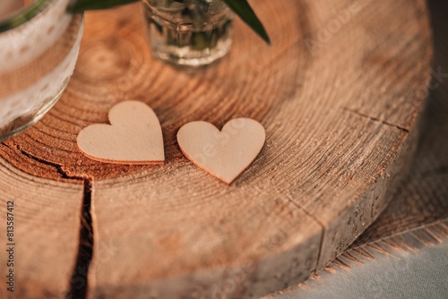 Closeup of two heart-shaped wooden pieces on a tree stump