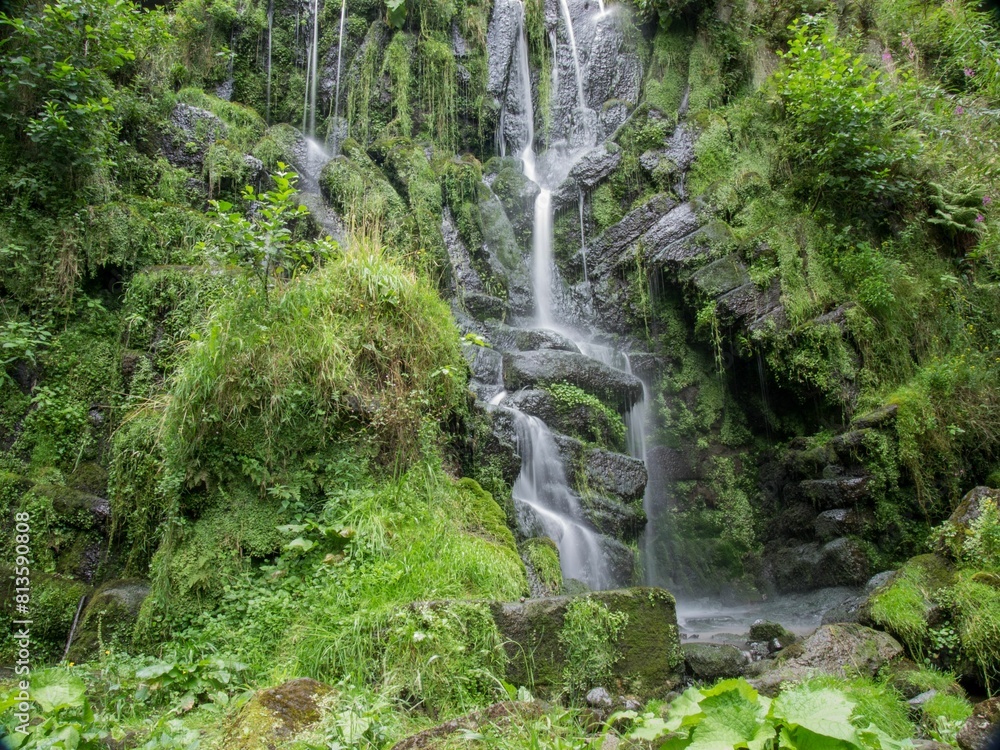 Small waterfall flowing over mossy rocks Small waterfall flowing over mossy rocks