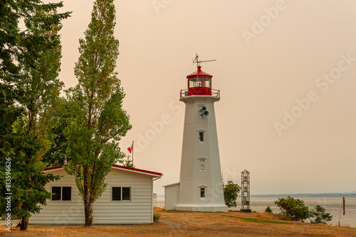 Cape Mudge lighthouse with red glow of forest wildfires, Quadra Island, British Columbia, Canada.