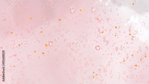 Macro shot of intensive bubbles in peach fuzz color inside it shower gel. photo