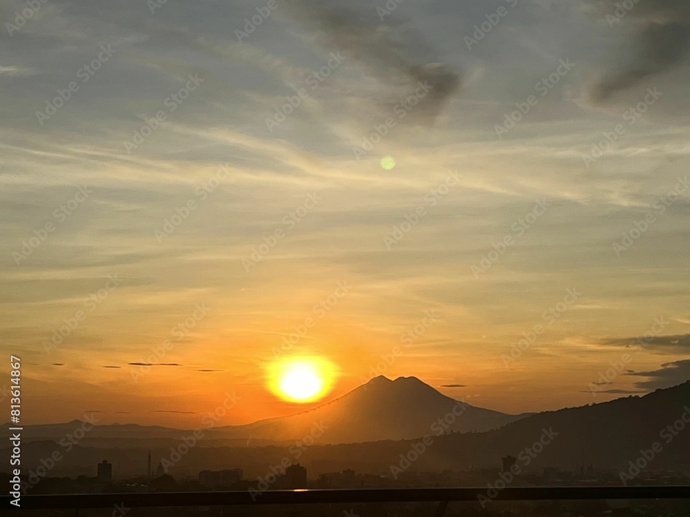 Fototapeta premium Beautiful shot of a landscape with mountains under the orange sun