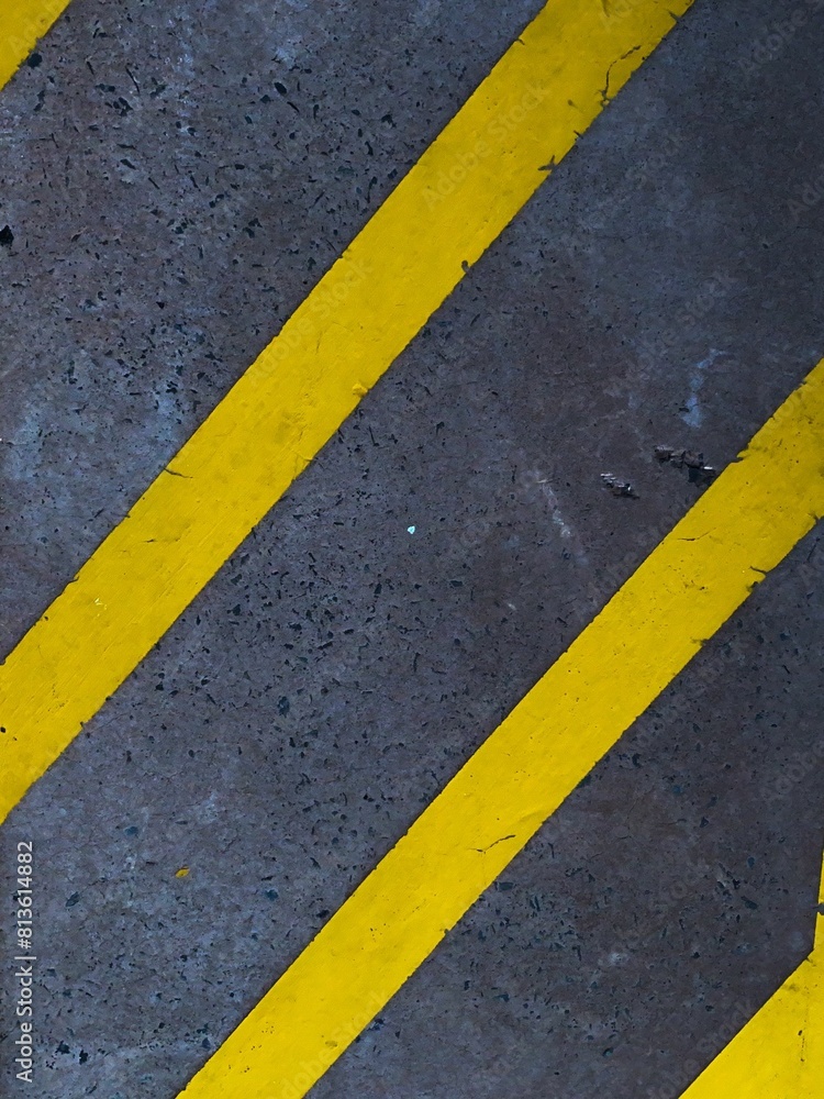 Fototapeta premium Vertical closeup shot of yellow markings on the street