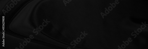 Black gray satin dark fabric texture luxurious shiny that is abstract silk cloth panorama background with patterns soft waves blur beautiful.