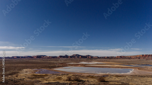 Landscape photo with a lake in the desert with mountains in the background
