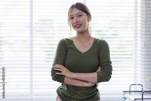 Young Asian business woman smiling confidently while standing alone in a bright modern office Free Download Young Asian business woman smiling confidently while standing alone in a bright modern office - GFXLoad