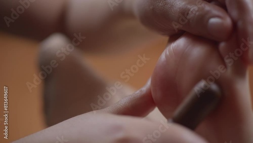 Thai foot massage using a wooden massage stick in a spa, close-up, slow motion