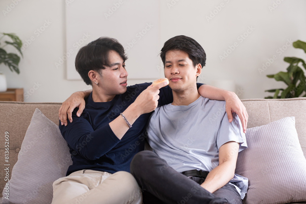 A male-male couple spends their free time happily doing holiday activities together, embracing each other and taking selfies together in the living room. A male-male couple spends their free time happily doing holiday activities together, embracing each other and taking selfies together in the living room.