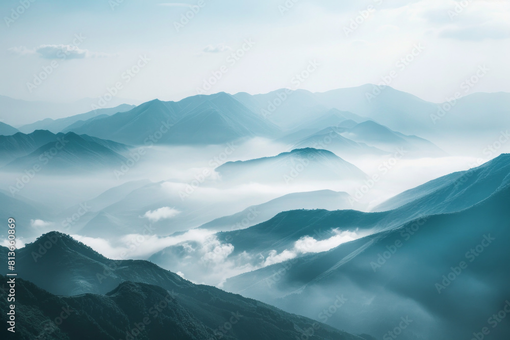 Obraz premium A tranquil view of the layers of mountain ridges disappearing into misty clouds, with their soft outlines and muted colors.