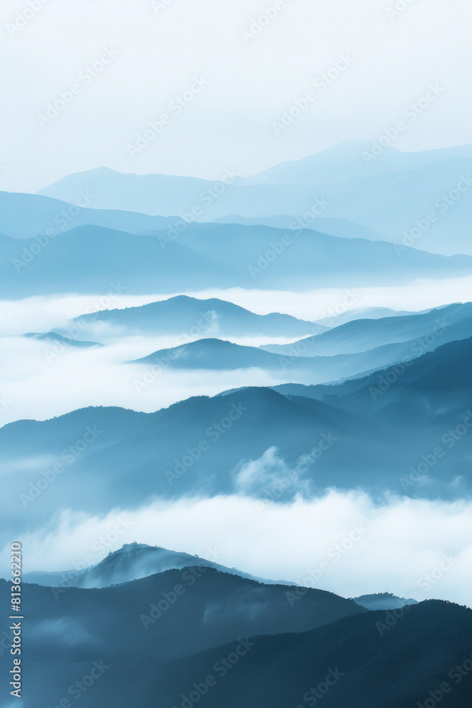 Obraz premium A tranquil view of the layers of mountain ridges disappearing into misty clouds, with their soft outlines and muted colors.
