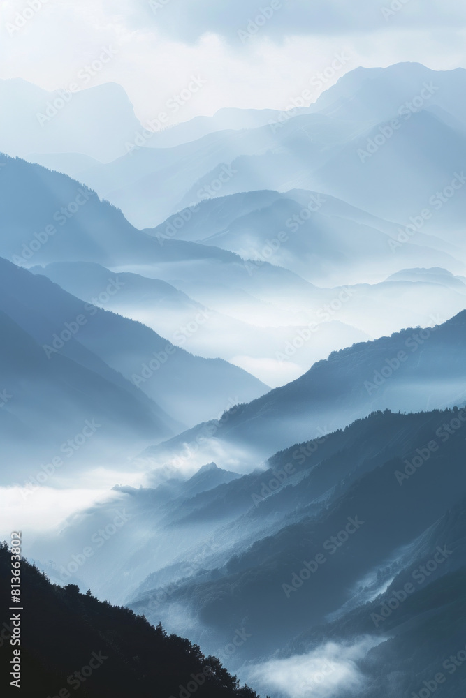 Fototapeta premium A tranquil view of the layers of mountain ridges disappearing into misty clouds, with their soft outlines and muted colors.