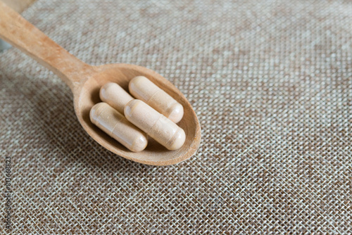Capsules in wooden spoon, food supplement, herbal preparations for health promotion