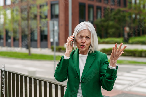 Valokuva Mature businesswoman is angry, phone calling smartphone with business partner