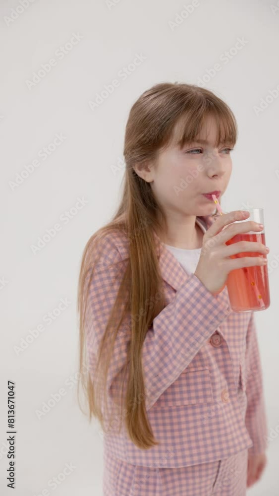 Vertical video. A pretty brown-haired teenage girl sucks strawberry juice from a straw. Her happy gesture and success are apparent as she looks directly at you. Vertical video. A pretty brown-haired teenage girl sucks strawberry juice from a straw. Her happy gesture and success are apparent as she looks directly at you.