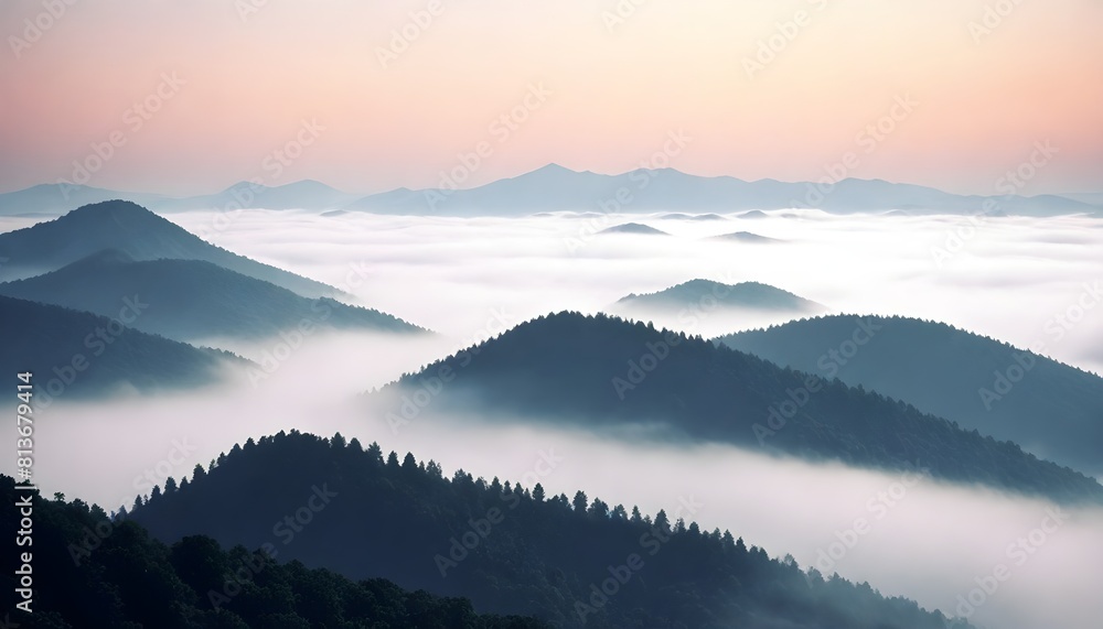 A mountain range covered in fog during the early morning hours, creating a mystical and atmospheric scene