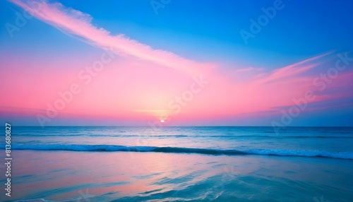 The sun sets in hues of pink and blue over the ocean, casting a colorful reflection on the waters surface © Sema