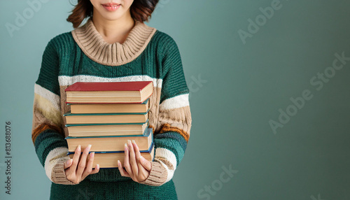 Woman hands holding pile of books over light blue background. Education, library, science, knowledge, studies, book swap, hobby, relax time photo