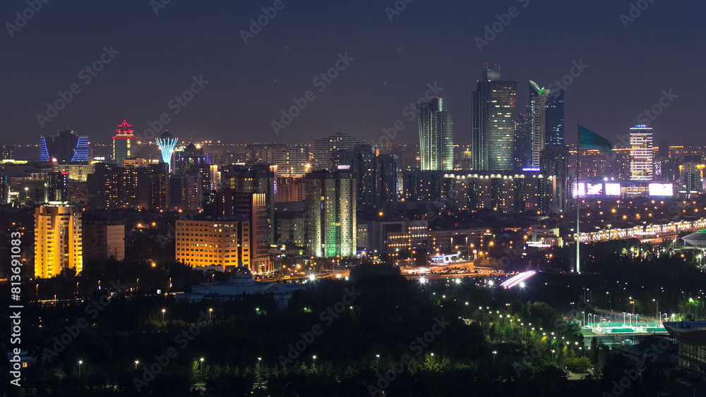 Fototapeta premium Elevated night view over the city center and central business district with bayterek Timelapse, Kazakhstan, Astana