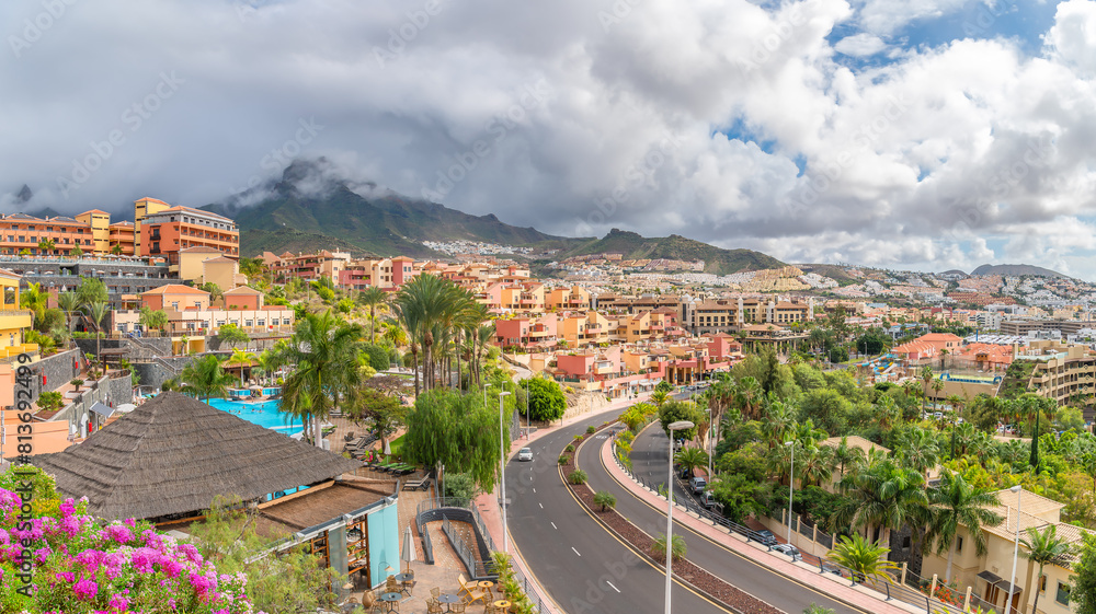Explore the vibrant Adeje coast in Tenerife, showcasing lush landscapes, Mediterranean architecture, and mountain views. Ideal for travel and vacation themes.