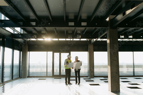 two architect engineers are walking in a constructed office building.