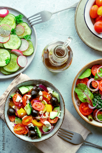 Fresh vegetarian salads, overhead flat lay shot of an assortment. Variety of plates and bowls with green vegetables. Healthy food, with olive oil