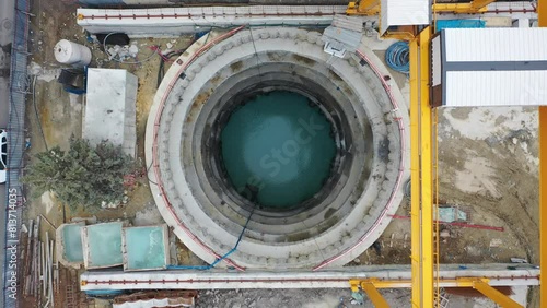 Aerial View of Urban Infrastructure: Deep Circular Shaft Construction for Metropolitan Development Project Filled with Water photo