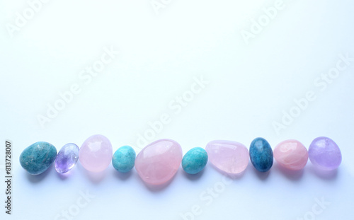 Multi-colored semi-precious round stones of rose quartz, kyanite and amazonite on a white background. Healing crystals
