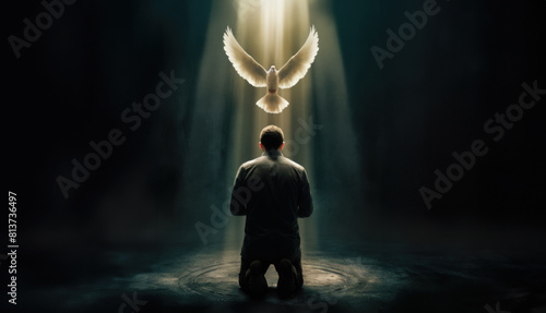 Pentecost concept art. Glowing white dove of the holy spirit descending upon a young christian man. Man on his knees receiving the holy ghost symbolized by a white glowing dove of fire. © ana