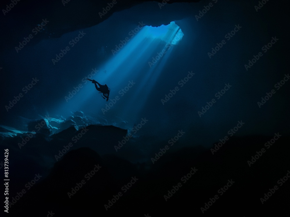 Diver caught in a beam of light in the underwater cavern at Buford Sink