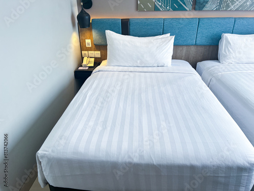 a bed with a striped sheet and two pillows on it