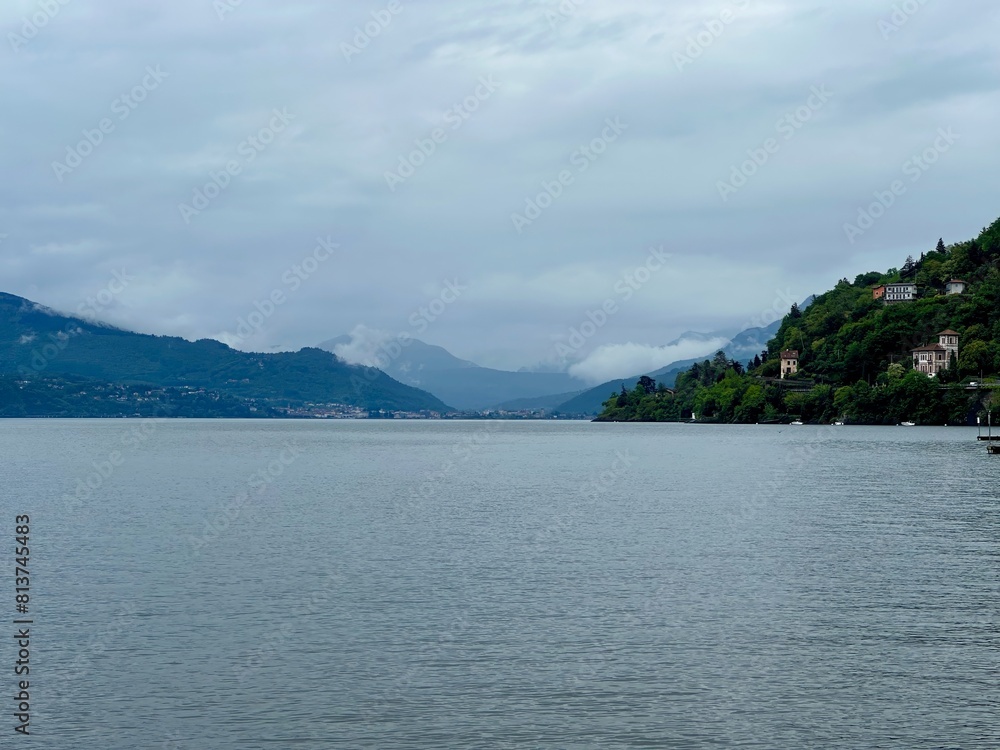 Obraz premium Atmospheric View from Cannobio Across Lake Maggiore Toward the Misty Hills of Luino, Verbano-Cusio-Ossola, Piedmont, Italy